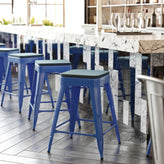 Kai Commercial Grade 24" High Backless Blue Metal Indoor-Outdoor Counter Height Stool with Teal-Blue Poly Resin Wood Seat